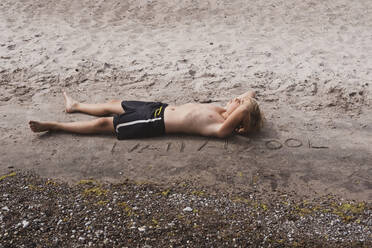 Boy lying on sand - JOHF01158