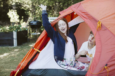 Brother and sister in tent in backyard - JOHF01193