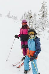 Boy and girl on ski slope - JOHF01249