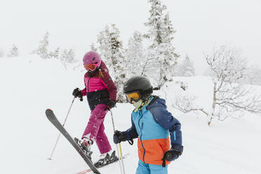 Boy and girl on ski slope - JOHF01258