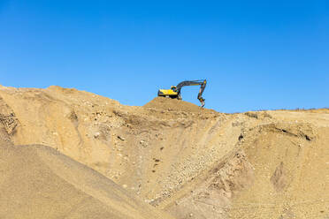 Digger on pile of sand - JOHF01273