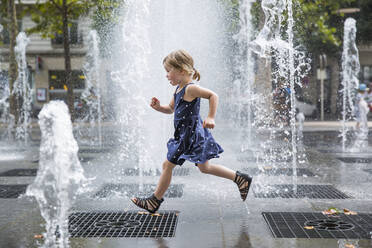 Girl running over fountain - JOHF01280