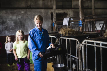 Woman with daughter in cowshed - JOHF01320