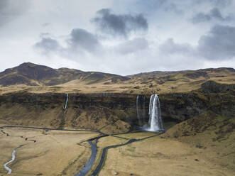Iceland, Aerial view of waterfall splashing down high cliff - DAMF00063