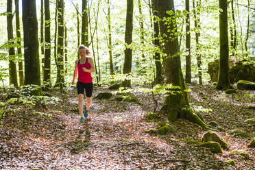 Frau joggt im Wald - JOHF01743