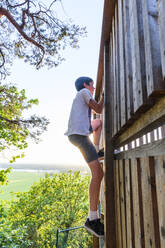 Boy climbing on wooden construction - JOHF01761