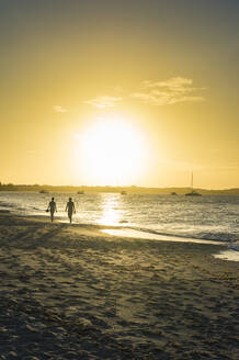 Silhouette Paar zu Fuß am Grace Bay Strand gegen den Himmel während des Sonnenuntergangs, Providenciales, Turks-und Caicosinseln - RUNF03349