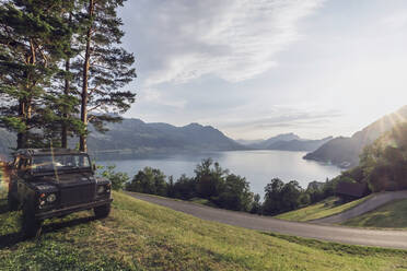 Schweiz, Gersau, Schwyz, 4x4 Auto geparkt entlang der kurvenreichen Straße mit dem Vierwaldstättersee im Hintergrund - MMAF01124