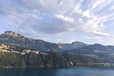 Schweiz, Gersau, Schwyz, Blick auf Wolken über dem Vierwaldstättersee und hohe bewaldete Felsen im Sommer - MMAF01127