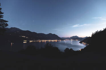 Schweiz, Gersau, Schwyz, Beleuchtete Häuser am Ufer des Vierwaldstättersees in der Abenddämmerung - MMAF01130