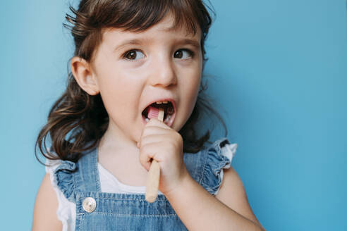 Portrait of a girl using a wooden bamboo toothbrush - GEMF03192