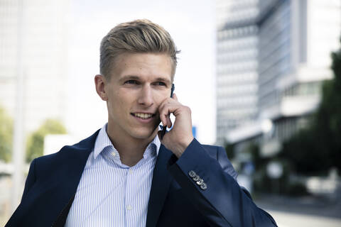 Junger Mann beim Telefonieren in der Stadt, lizenzfreies Stockfoto