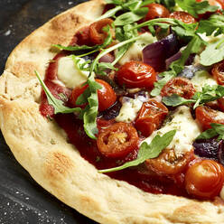 Vegetarian pizza with cherry tomatoes, arugula, Mozzarella and onions - KSWF02105