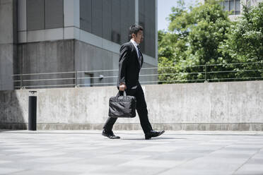 Young businessman walking in the city - JPIF00179