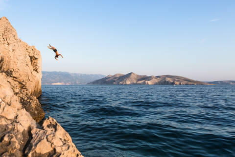 Kroatien, Krk, Mann taucht ins Meer, lizenzfreies Stockfoto