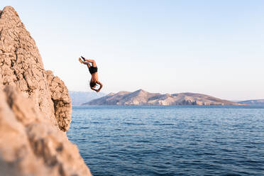 Croatia, Krk, man diving into sea - WVF01438