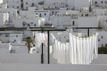 Spain, Andalusia, Conil de la Frontera, drying clothes with building in background - TLF00768