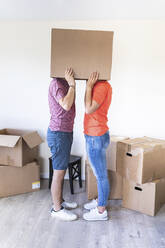 Ehepaar zieht in ein neues Haus ein und versteckt sich unter einem Karton - WPEF01922