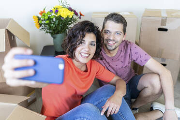 Happy couple taking a selfie in new home - WPEF01924