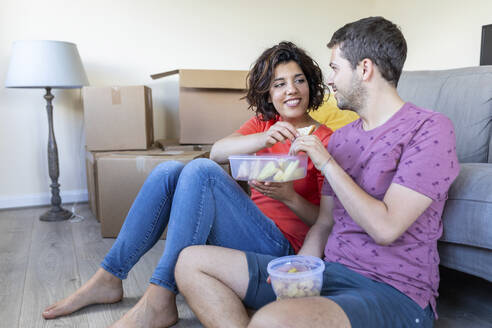 Glückliches Paar, das in ein neues Haus einzieht, macht eine Pause und isst zu Mittag - WPEF01943