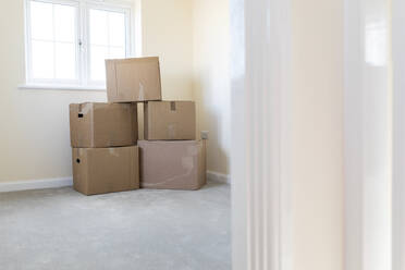 Cardboard boxes in an empty room in a new home - WPEF01945