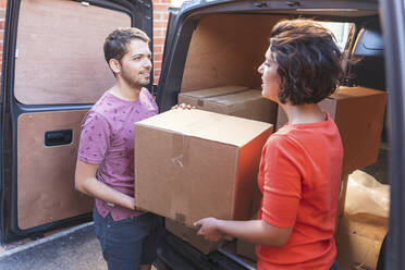 Couple unloading cardboard boxes from van - WPEF01960