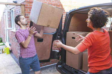 Ehepaar entlädt Kartons aus einem Lieferwagen - WPEF01962