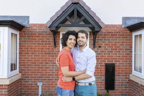 Portrait of happy couple in front of their new home - WPEF01967