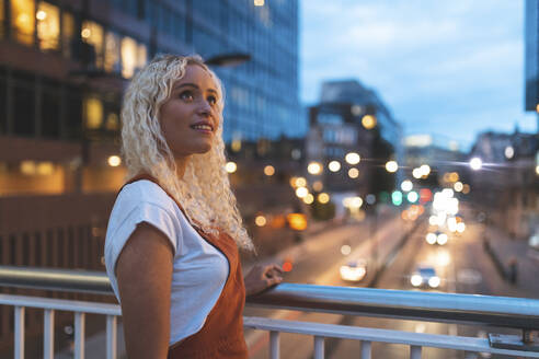 Young woman in the city at dusk with urban street in London - WPEF01975