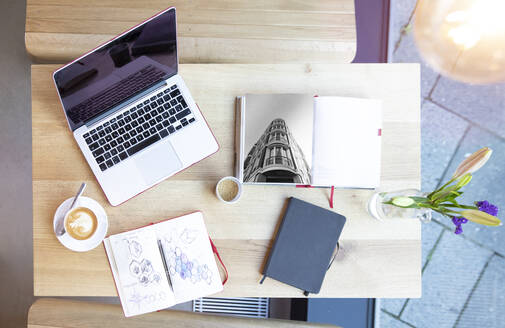 Laptop and books on table in a cafe - FKF03621