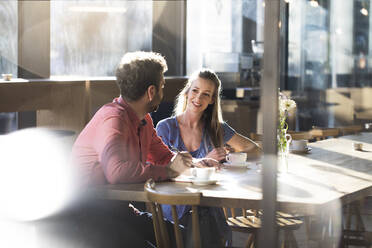 Woman and man talking at table in a cafe - FKF03631