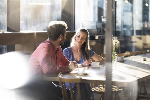 Frau und Mann unterhalten sich am Tisch in einem Cafe - FKF03631