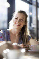 Porrait of smiling woman in a cafe - FKF03633
