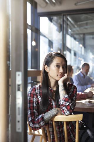 Porträt einer Frau mit Kollegen in einem Kaffeehaus, lizenzfreies Stockfoto