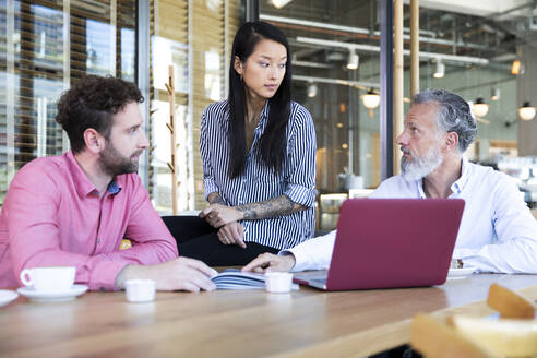 Casual business people having a meeting in a cafe - FKF03679