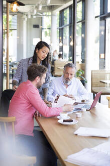 Casual business people having a meeting in a cafe - FKF03680