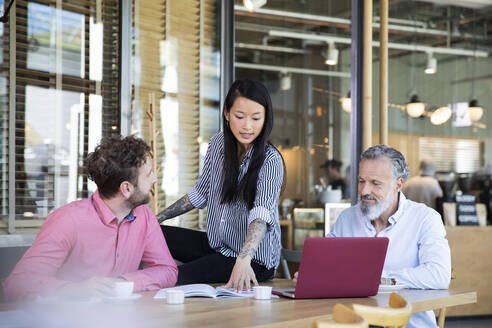 Casual business people having a meeting in a cafe - FKF03681