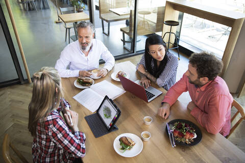 Lässige Geschäftsleute beim Geschäftsessen in einem Cafe, lizenzfreies Stockfoto