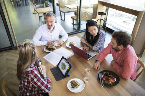 Casual business people having business lunch in a cafe - FKF03685