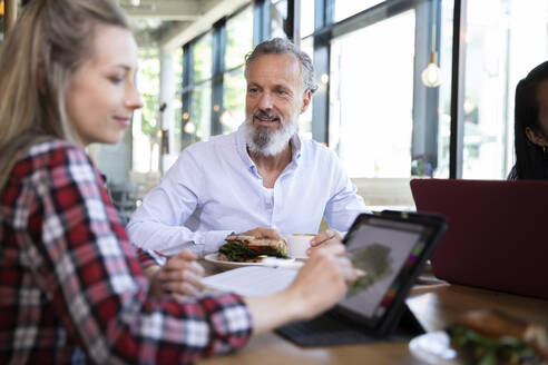 Casual business people having business lunch in a cafe - FKF03686