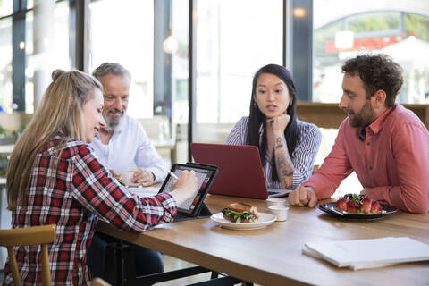 Lässige Geschäftsleute bei einem Treffen in einem Café, lizenzfreies Stockfoto