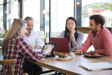 Casual business people having a meeting in a cafe - FKF03687