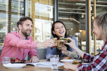 Glückliche Freunde beim Mittagessen in einem Cafe - FKF03695