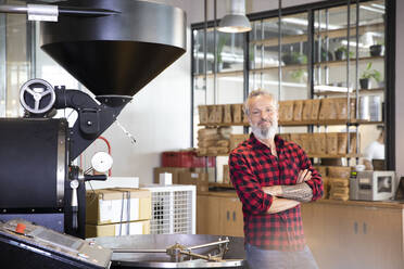 Porträt eines selbstbewussten reifen Mannes in einer Kaffeerösterei - FKF03697