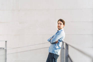 Portrait of confident casual businessman leaning against a railing - AFVF03976