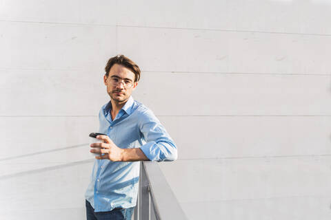 Porträt eines lässigen Geschäftsmannes mit Kaffee zum Mitnehmen, lizenzfreies Stockfoto