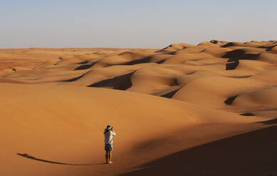 Man taking pictures in the desert, Wahiba Sands, Oman - WWF05279