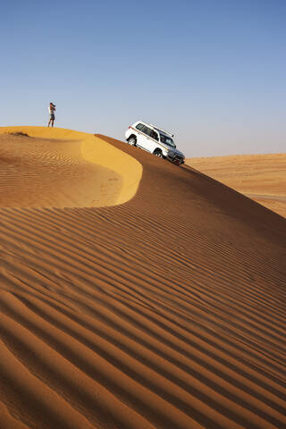 Mann mit Geländewagen, Fotografieren in der Wüste, Wahiba Sands, Oman, lizenzfreies Stockfoto