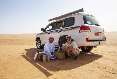 Tourist bei einer Kaffeepause mit seinem einheimischen Fahrer in der Wüste, Wahiba Sands, Oman - WWF05287