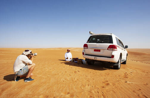 Tourist fotografiert seinen einheimischen Fahrer in der Wüste, Wahiba Sands, Oman - WWF05289